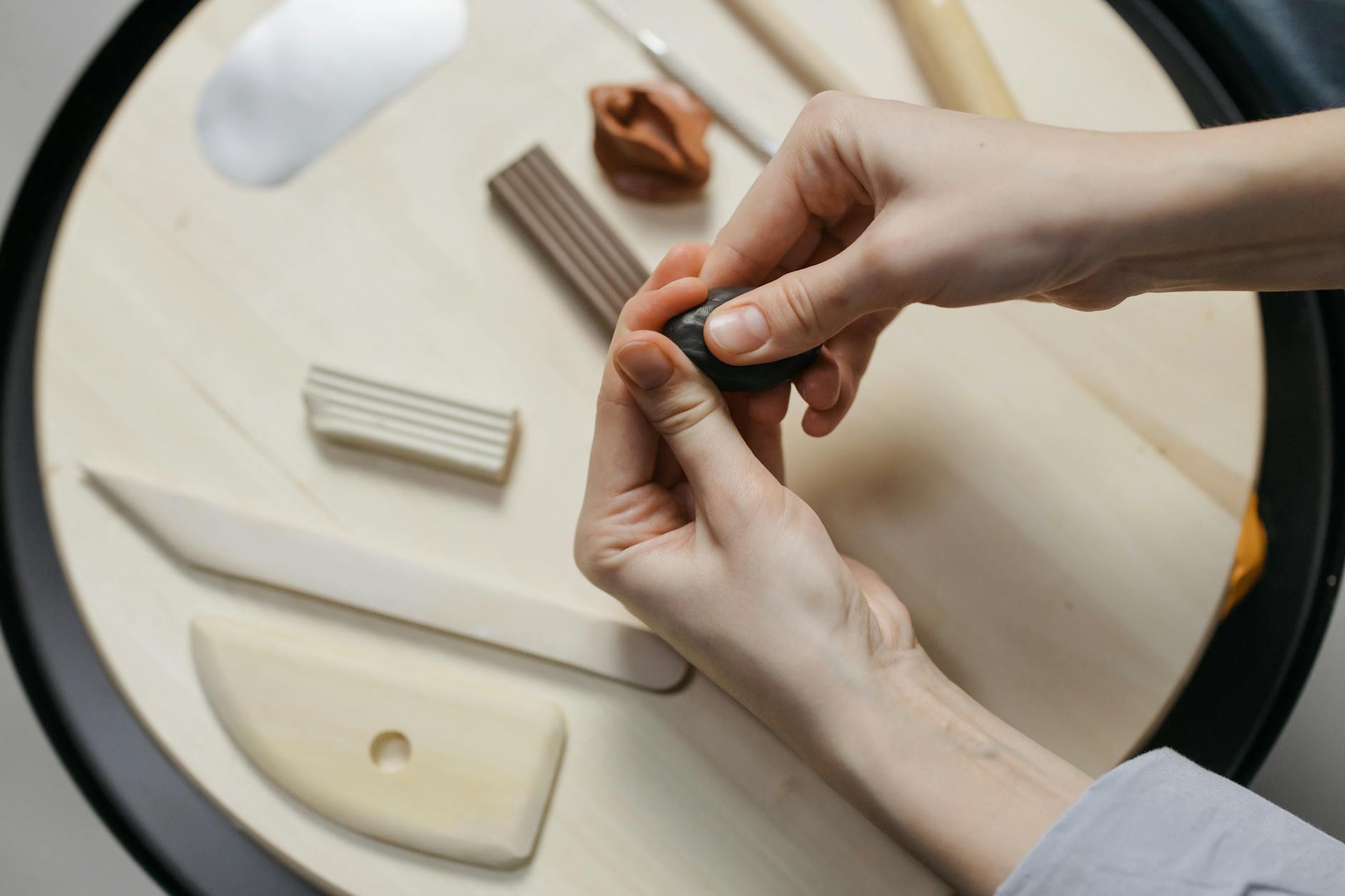 a person holding a black clay